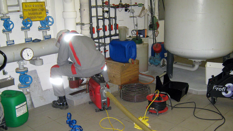 Monteur beim Ausfräsen der Grundleitung mit der Motorspirale